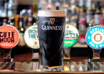 Diageo Faces Profit Slump and Tariff Blow Amid Leadership Crisis Published: 05 August '2025. The English Chronicle Desk Diageo, the world’s leading spirits producer and owner of iconic brands such as Guinness, Johnnie Walker, and Smirnoff, has reported a sharp 28% fall in its annual operating profits. This downturn has been attributed to a combination of internal challenges, shifting consumer habits, and external economic pressures—including a looming $200 million hit from new U.S. tariffs imposed under former President Donald Trump's trade policy. The company, listed on the FTSE 100, is also navigating a leadership transition following the sudden resignation of CEO Debra Crew. Crew’s departure, said to be by mutual agreement, came amid growing concern among investors over the company’s declining share price and overall performance. She had taken charge in 2023 after the unexpected death of long-serving and well-respected CEO Ivan Menezes. Under Crew, Diageo faced multiple setbacks, including sluggish sales in Latin America and supply chain issues that caused a Guinness shortage during last year’s holiday season. Interim CEO Nik Jhangiani, the company’s current CFO, has expanded Diageo’s cost-cutting initiative, increasing the savings target from £500 million to £625 million. While some roles are expected to be cut, Jhangiani emphasized that the overall workforce may still grow as part of a broader restructuring. Despite the challenging year, he pointed to strong performances from certain products such as Guinness, Don Julio tequila, and Crown Royal Blackberry as bright spots in an otherwise underwhelming fiscal report. Compounding its financial concerns, Diageo is bracing for a significant hit from newly enforced U.S. tariffs. The 10% levy on UK-imported spirits, along with a 15% tax on EU imports—while sparing Mexican and Canadian products—is expected to cost the company approximately $200 million annually. These tariffs took effect after the implementation of the UK-US trade agreement on 30 June, with additional EU tariffs set to begin on 7 August. In response, Diageo has ramped up contingency planning, aiming to counter the tariff effects through inventory management, supply chain adjustments, and the reallocation of investments. According to internal projections, these measures could offset up to half of the anticipated financial impact. Despite these efforts, Diageo’s stock has plummeted over 25% since the start of the year, placing it among the poorest performers on the FTSE 100 index. Analysts also point to broader market trends, such as shifting drinking habits among younger consumers and the ongoing cost-of-living crisis, as factors contributing to the public’s growing preference for more affordable, non-premium brands. With a new CEO yet to be named and economic headwinds continuing to buffet the global spirits industry, Diageo stands at a crossroads—needing to stabilize operations, restore investor confidence, and adapt to an evolving market landscape.