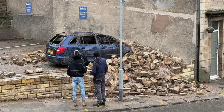wall collapses on to car